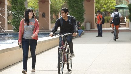 Two undergrads talking, one is on a bike