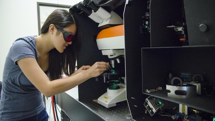 Undergrad student preparing to use microscope in lab