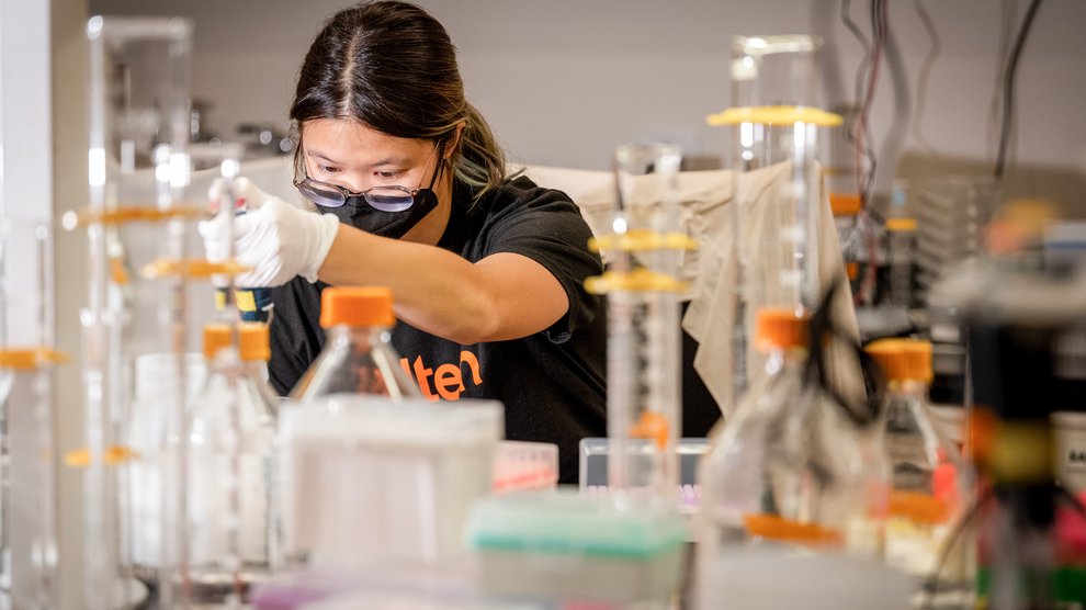 Student in lab with beakers.