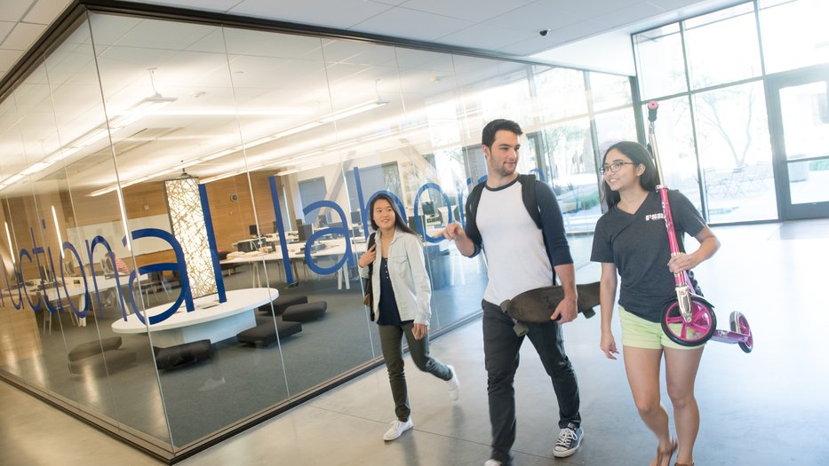 Students walk through Annenberg, one student carries a scooter