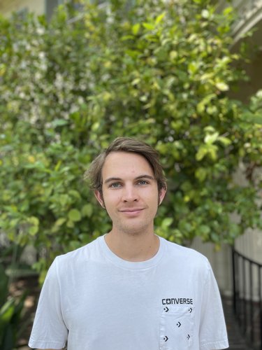 Profile photo of Miles Jones standing in front of a tree