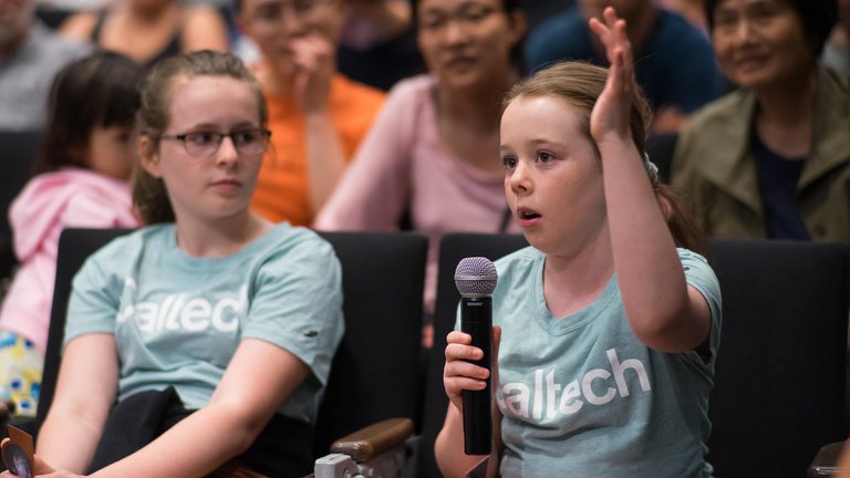 Two enthusiastic young audience members ask a question at a Stargazing Lecture.