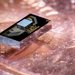 An electronics chip (the smaller chip on the top) integrated with a photonics chip, sitting atop a penny for scale. 