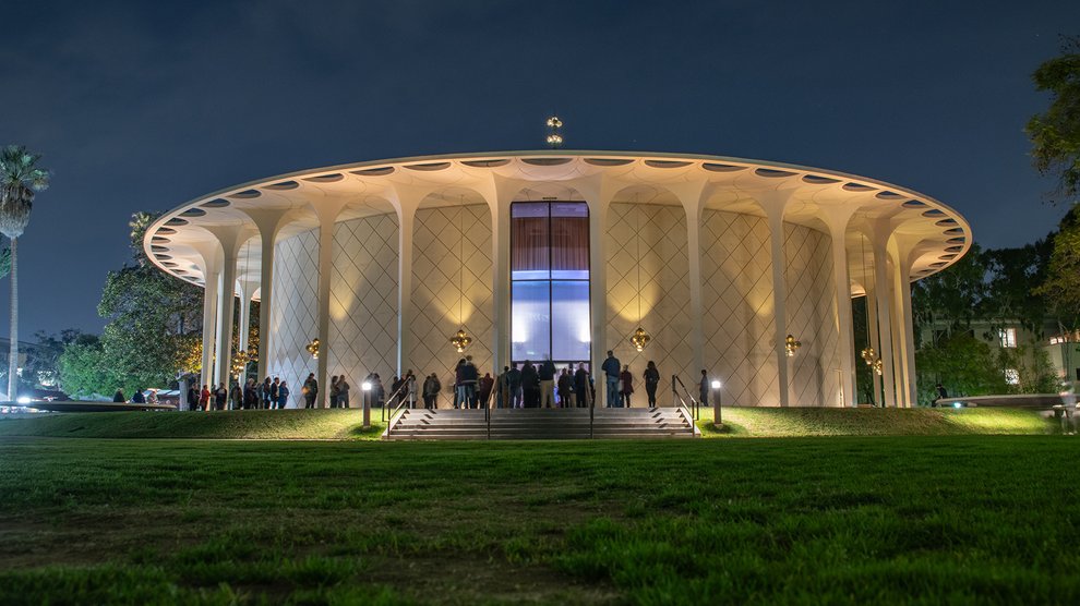 Beckman auditorium at night with audience in front