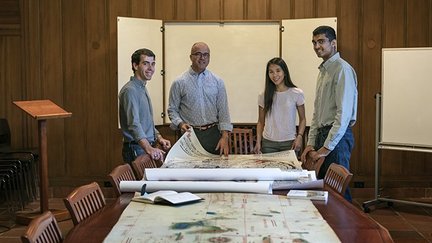 Nico with students and several large maps before them