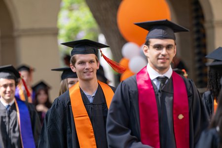 Caltech graduates enter their commencement ceremony wearing caps and gowns