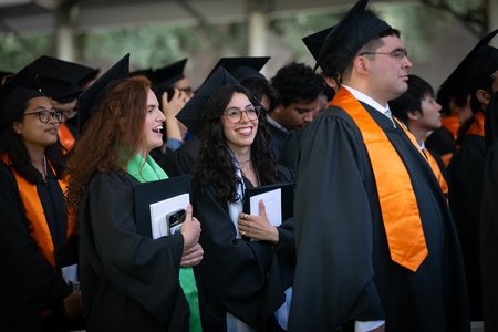 Four Caltech graduates standing at the close of their commencement ceremony