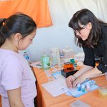 Caltech students share a demonstration with a young girl