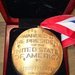 The back side of a National Medal of Science says, "Awarded by the President of the United States of America to John O. Dabiri 2024"