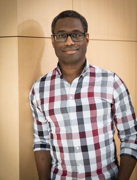 A person in a checkered shirt and glasses