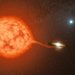 Artwork showing a large reddish star next to a small white dwarf star, with a third star in the background.