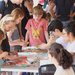 People gather around a tabletop activity