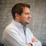 Phil Hopkins standing in front of a chalkboard with equations