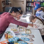 An adult helps a child use a microscope