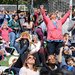 A densely gathered crowd wearing eclipse glasses and looking upward