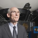 A man standing in front of a large model of a spacecraft