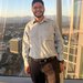 Tony Rodriguez posing inside a tall building with a view outside.