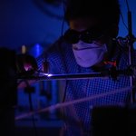 Glowing hot pink plasma can be seen in a dark laboratory room.